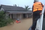 Bộ đội Biên phòng tỉnh Quảng Trị di dời những người dân bị mắc kẹt trong lũ đến nơi an toàn. (Ảnh: Hồ Cầu/TTXVN)