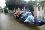 Người dân dùng thuyền di chuyển tài sản đến cất ở nơi khô ráo. (Ảnh: Trịnh Bang Nhiệm/TTXVN)