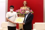 Ông Nguyễn Xuân Ký, Bí thư Tỉnh ủy Quảng Ninh tặng bằng khen cho Nguyễn Hoàng Khánh, nhà vô địch Đường lên đỉnh Olympia năm 2021. (Ảnh: Thanh Vân/TTXVN)