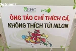 Tình nguyện viên nước ngoài cùng dọn rác nơi thả cá ông Công ông Táo. (Ảnh: Minh Anh/Vietnam+)