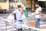 Vận chuyển hàng hóa tiếp tế vào cho người dân trong khu vực bị phong tỏa ở phố Phủ Doãn. Ảnh: Hoàng Hiếu/TTXVN)