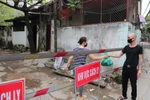 Người thân chuyển nhu yếu phẩm cho người trong khu vực cách ly ngõ 165 Cầu Giấy. (Ảnh: Thành Đạt/TTXVN)