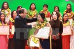Thủ tướng Nguyễn Xuân Phúc tặng hoa cho các phụ nữ điển hình tiên tiến. (Ảnh: TTXVN)