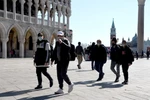 Du khách đeo khẩu trang phòng lây nhiễm COVID-19 tại Italy. (Ảnh: AFP/TTXVN)