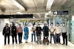 Nhóm công dân Việt Nam cùng cán bộ ĐSQ và nhân viên Vietnam Airlines trước giờ lên máy bay. (Ảnh: TTXVN phát)