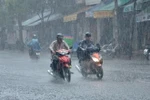 Mưa trắng xóa khiến tầm nhìn hạn chế, gây nguy hiểm cho người đi đường. (Ảnh: TTXVN phát)