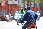 Dưới cái nóng thiêu đốt, người dân tham gia giao thông phải trang bị áo mũ chống nắng kín mít để tránh nắng. (Ảnh: Hoàng Hiếu/TTXVN)