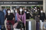 Hành khách đeo khẩu trang đề phòng lây nhiễm COVID-19 tại sân bay quốc tế Los Angeles, bang California, Mỹ. (Ảnh: AFP/TTXVN)