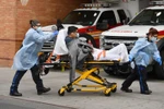Nhân viên y tế chuyển bệnh nhân mắc COVID-19 vào một bệnh viện ở New York, Mỹ. (Ảnh: AFP/TTXVN)