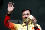 Xạ thủ Hoàng Xuân Vinh cùng tấm huy chương Vàng lịch sử. (Nguồn: EPA/TTXVN)