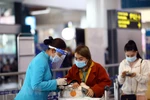 Nhân viên của hãng hàng không Vietnam Airlines đeo đầy đủ khẩu trang, mặt nạ chống giọt bắn để đảm bảo phòng chống dịch. (Ảnh: Huy Hùng/TTXVN)
