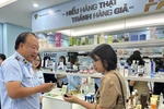 Ông Trần Hữu Linh, Tổng cục trưởng Tổng cục Quản lý thị trường hướng dẫn cách phân biệt hàng chính hãng. (Ảnh: Đức Duy/Vietnam+)