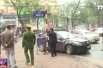 Lực lượng chức năng tiến hành tháo dỡ biển quảng cáo tại cửa hàng lấn chiếm vỉa hè trên phố Quang Trung. (Ảnh: Thùy Dương/TTXVN)