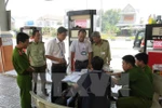 Lực lượng chức năng lập biên bản một cây xăng có gắn chíp gian lận. (Ảnh: TTXVN)