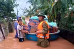 Ông Phan Thanh Miên (phải) dầm mưa, lội nước lũ cùng các đoàn cứu trợ đi cấp phát nhu yếu phẩm tiếp tế cho bà con trong đợt mưa lũ lịch sử vừa qua. (Ảnh: TTXVN phát)