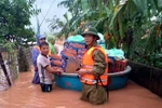 Ông Phan Thanh Miên (phải) dầm mưa, lội nước lũ cùng các đoàn cứu trợ đi cấp phát nhu yếu phẩm tiếp tế cho bà con trong đợt mưa lũ lịch sử vừa qua. (Ảnh: TTXVN phát)