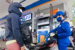 Mua bán xăng dầu tại một điểm kinh doanh của Petrolimex. (Ảnh: Trần Việt/TTXVN)