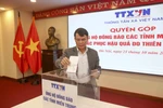 Tổng Giám đốc TTXVN Nguyễn Đức Lợi tham gia quyên góp. (Ảnh: Tuấn Đức/TTXVN)