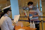 Lực lượng chức năng kiểm tra khai báo y tế của những hành khách đáp chuyến bay từ Hàn Quốc đến sân bay Cam Ranh trong chiều 25/2. (Ảnh: Nguyễn Dũng/TTXVN)