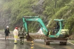 Lực lượng chức năng túc trực, xử lý các điểm bị sạt lở trên đèo Bảo Lộc, giúp các phương tiện lưu thông an toàn. (Ảnh: TTXVN phát)