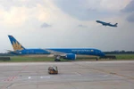 Máy bay của hãng hàng không Vietnam Airlines cất và hạ cánh tại sân bay Tân Sơn Nhất. (Ảnh: Ngọc Hà/TTXVN)