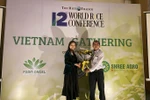 Anh hùng Lao động-Kỹ sư Hồ Quang Cua, cha đẻ gạo ST25, nhận hoa chúc mừng từ ban tổ chức. (Ảnh: VFA cung cấp)