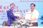 Giáo sư, tiến sỹ Trần Văn Thuấn, Giám đốc Bệnh viện K và ông Phạm Văn Học, Tổng Giám đốc Bệnh viện Đa khoa Hùng Vương ký kết hợp đồng hợp tác chuyên môn giữa hai bệnh viện. (Ảnh: Trung Kiên/TTXVN)