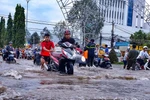 Đường Nguyễn Văn Cừ, quận Ninh Kiều bị ngập sâu, người dân vất vả khi di chuyển. (Ảnh: Thanh Liêm/TTXVN)