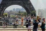 Khách du lịch bên Tháp Eiffel ở Paris (Pháp). (Nguồn: AFP/TTXVN)