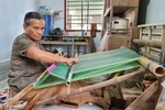 Nghệ nhân lớn tuổi người Chăm dệt vải thổ cẩm truyền thống. (Ảnh: Nguyễn Thành/TTXVN)