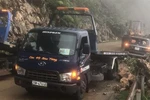 Đơn vị chức năng triển khai công tác cứu hộ cứu nạn xe ôtô bán tải bị đất đá rơi vào. (Ảnh: TTXVN phát)