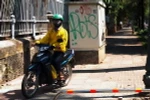 Nhiều người vẫn đi xe máy trên vỉa hè lắp thí điểm barie một thanh. (Ảnh : Hoàng Hải/TTXVN)