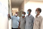Cử tri đồng bào Khmer xã Trà Côn, huyện Trà Ôn xem danh sách người ứng cử đại biểu Quốc hội khóa XV. (Ảnh: Lê Thúy Hằng/TTXVN)