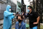 Sở Y tế Thành pố Hồ Chí Minh tổ chức hướng dẫn cho người dân tự lấy mẫu xét nghiệm COVID-19 bằng test nhanh kháng nguyên virus SARS-CoV-2. (Ảnh: Thanh Vũ/TTXVN)