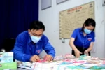Các cán bộ Quận đoàn Phú Nhuận chuẩn bị sách phát cho người dân trong khu phong tỏa. (Ảnh: Thành Chung/TTXVN)