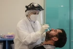 Nhân viên y tế lấy mẫu xét nghiệm COVID-19 cho người dân tại Sao Paulo, Brazil, ngày 7/4 vừa qua. (Ảnh: THX/TTXVN)