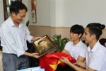 Đại diện nhóm TeamLee trao ảnh phục dựng truyền thần cho thân nhân liệt sỹ Nguyễn Chính (1937-1964). (Ảnh: Phan Sáu/TTXVN)