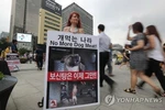 Một nhà hoạt động cầm biểu ngữ kêu gọi người dân Hàn Quốc dừng ăn thịt chó. (Nguồn: Yonhap)