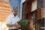 Ông Huỳnh Trí với những kỷ vật theo ông trong suốt cuộc đời binh nghiệp. (Ảnh: Công Mạo/TTXVN)