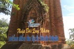 Tháp Đôi bị khoan vào tường gạch, bắt vít sắt thép để gắn biển giới thiệu tên di tích. (Ảnh: TTXVN)