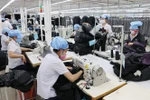 Công nhân đang sản xuất hàng may mặc. (Ảnh: Trần Lê Lâm/TTXVN)