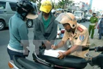 Cảnh sát giao thông xử lý người điều khiển phương tiện vi phạm giao thông. (Ảnh: Bùi Tường/TTXVN)