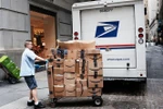 Nhân viên Công ty Dịch vụ bưu chính Mỹ (USPS) chuyển bưu kiện tại New York, Mỹ. (Nguồn: AFP/TTXVN) 