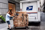 Nhân viên Công ty Dịch vụ bưu chính Mỹ (USPS) chuyển bưu kiện tại New York, Mỹ. (Nguồn: AFP/TTXVN) 