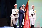 Thủ tướng Phạm Minh Chính gắn Huân chương Hồ Chí Minh lên lá cờ truyền thống của lực lượng Cảnh sát Nhân dân, Bộ Công an. (Ảnh: Phạm Kiên/TTXVN) 