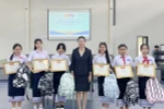 Bà Đặng Thị Hải Tâm, Tổng lãnh sự Việt Nam tại tỉnh Savannakhet, chụp ảnh chung với các học sinh đoạt giải. (Ảnh: TTXVN phát)