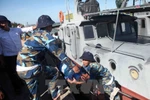 Vận chuyển nước lên tàu HQ211 để tiếp tế ra cho lực lượng tìm kiếm trên biển. (Ảnh: Thanh Tùng/TTXVN)