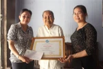 Bà Trần Thị Lan Phương (trái) trao Bằng khen của Hội liên hiệp phụ nữ Việt Nam cho cụ bà Trần Thị Lén. (Ảnh: Huỳnh Sử/TTXVN)