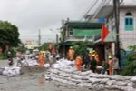 Đóng cát vào bao tải, đắp đê ngăn bùn và đất đá tràn. (Ảnh: Minh Quyết/TTXVN)