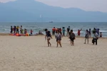 Khách du lịch và người dân đi dạo chơi, tắm biển trên các bãi biển. (Ảnh: Trần Lê Lâm/TTXVN) 